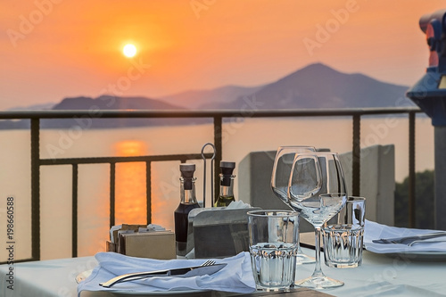 столик в ресторане с видом на море с закатом в горах