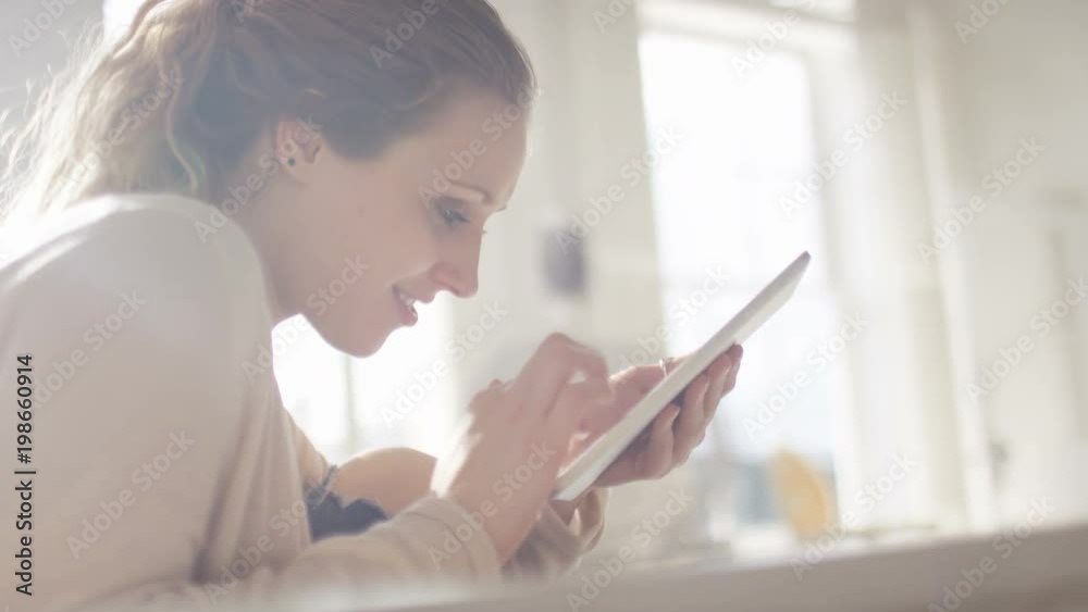 Young woman on a digital tablet at home, in slow motion Young woman on a digital tablet at home, in slow motion