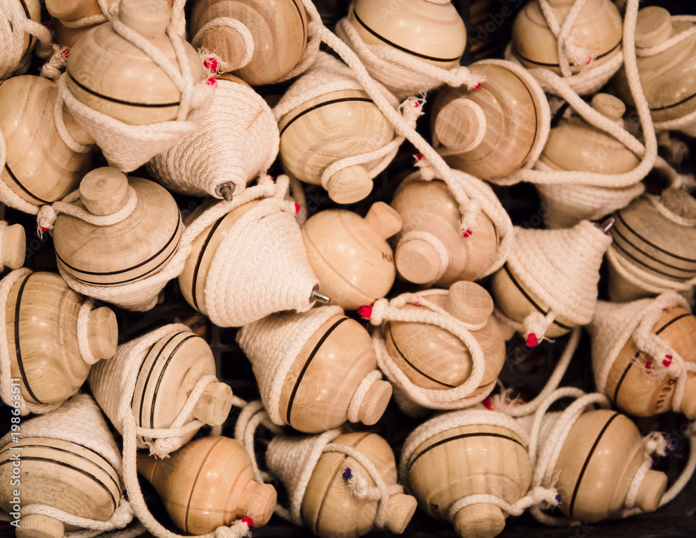Several wooden spinning top toys with string.