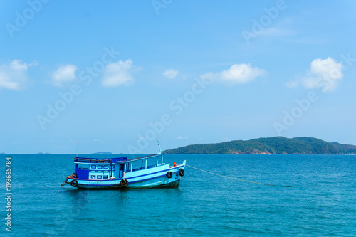 landscape view of seascape and skyline in the ocean with fishing boat and island. © yanadhorn