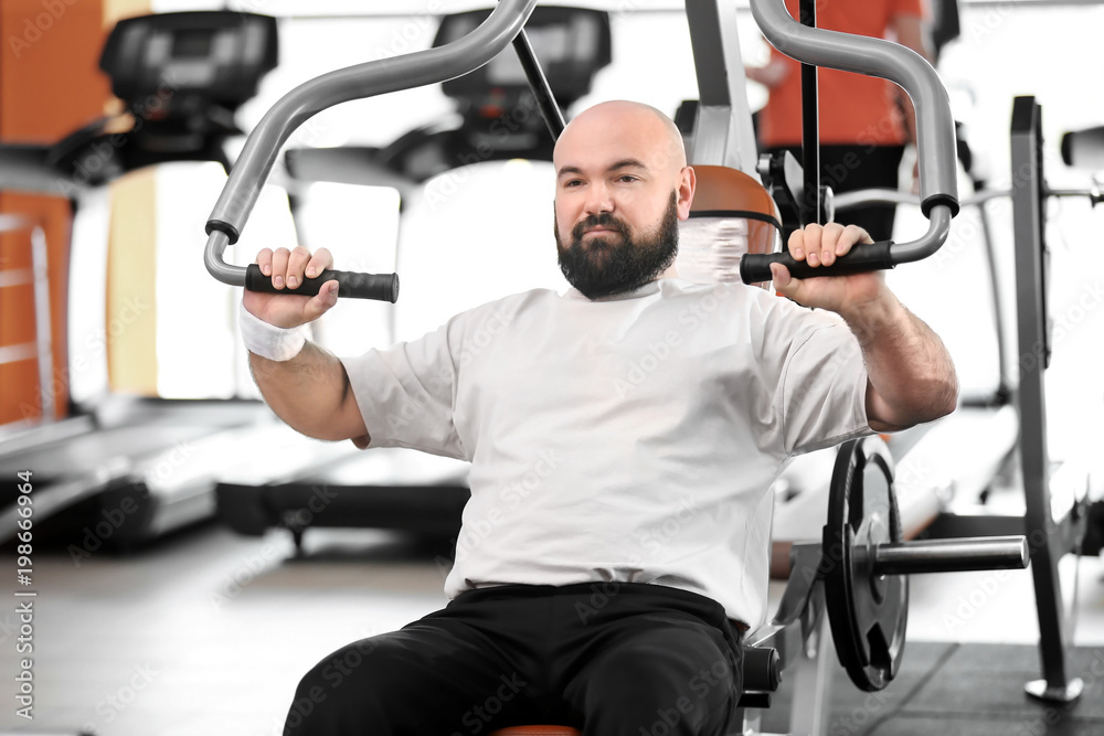Overweight man training in gym Overweight man training in gym