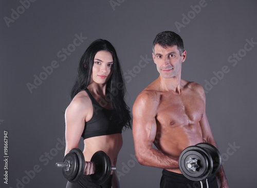 Athletic man and woman with a dumbells