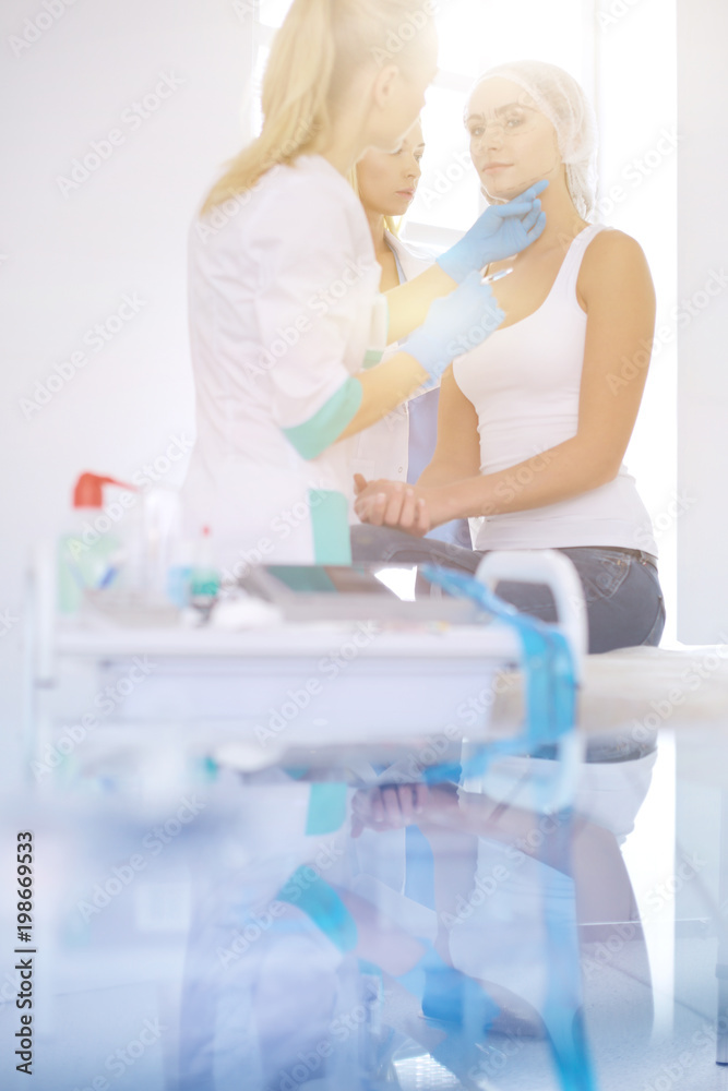 Fototapeta premium Beautiful woman face near doctor with syringe