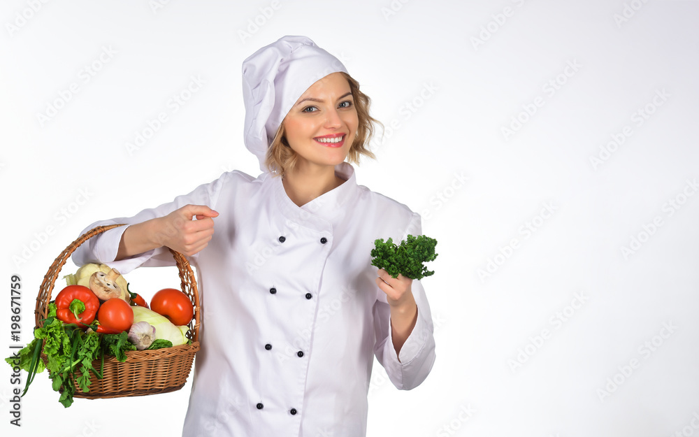 Smiling happy female chef woman holds basket vegetable. Professional cook in white suit holding basket of fresh veggies. Green grocery concept. Food preparation. Copy space for advertise restaurant. Smiling happy female chef woman holds basket vegetable. Professional cook in white suit holding basket of fresh veggies. Green grocery concept. Food preparation. Copy space for advertise restaurant.