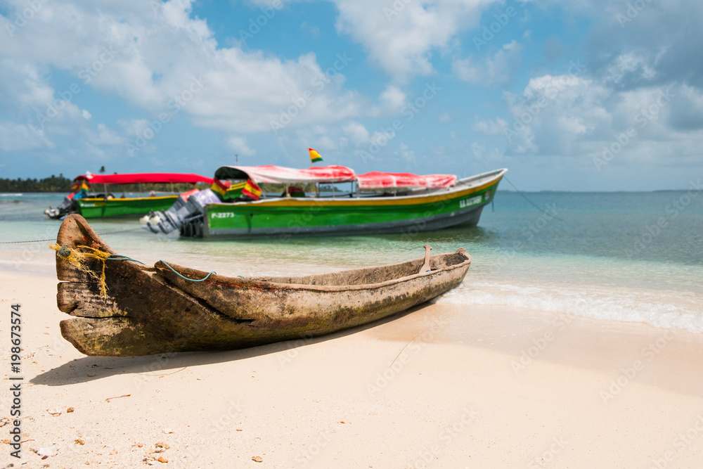old wooden canoe boat and motorboats on beach, 