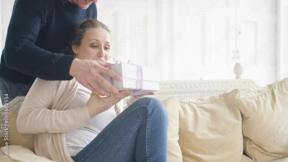 Young woman receives a surprise gift from her partner Young woman receives a surprise gift from her partner