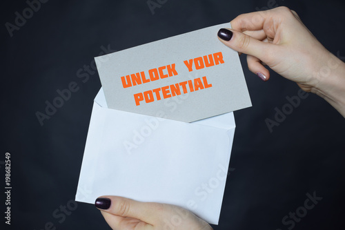 In the hands of a businessman an envelope with the inscription:UNLOCK YOUR POTENTIAL