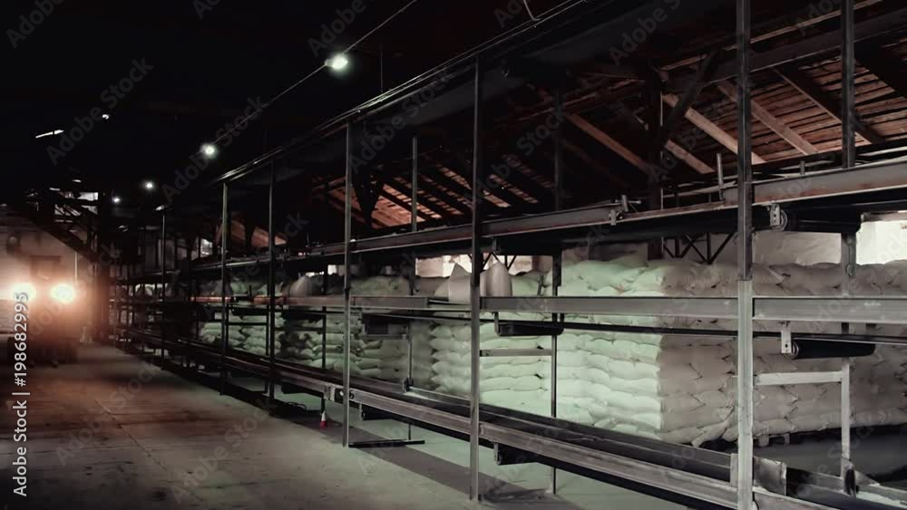 Loader working in a warehouse, headlights lighting Loader working in a warehouse, headlights lighting