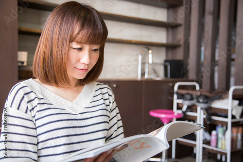 美容室で雑誌を読む女性（微笑む） 