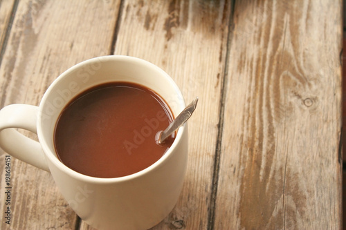 morning white cooffee cup with spoon on plank wood table background