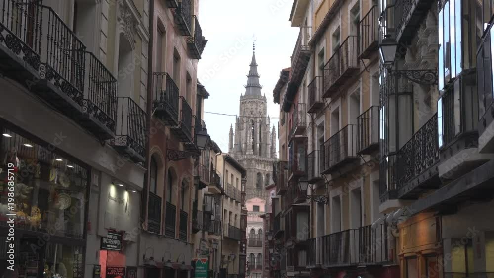 Gothic tower behind buildings Gothic tower behind buildings