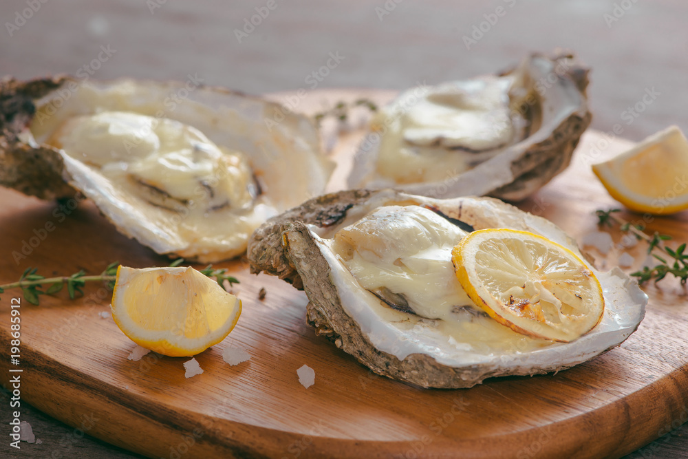 Fresh Oysters in shell with lemon on cutting board