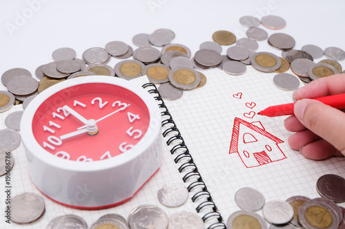 When you will have your own house concept: Top view and close up of many coins, pages of notebook with your house and clock (mean time), finance, saving money. photo