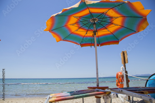 image of relaxing at the beach with umbrellas and sunbeds 