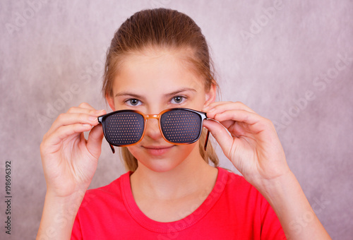 Obraz na płótnie Girl holding in the hands of the training glasses for vision correction w salonie