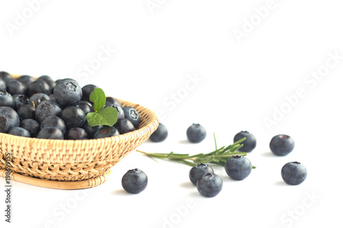 Fresh wild blueberries heap in wooden basket on white isolated background for wallpaper and all web design. Blueberry is healthy and delicious fruits which have high antioxidant and vitamin C.