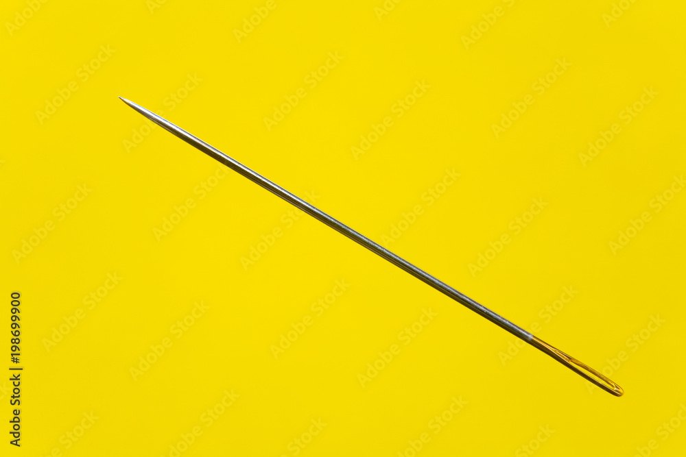 Beautiful thin elegant needle on a yellow background. Beautiful thin elegant needle on a yellow background.