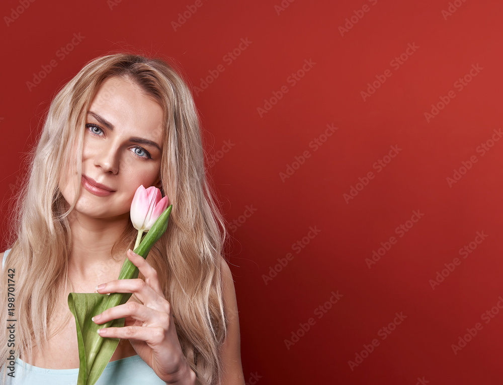 young girl in a blue dress with white and pink tulips on a red background young girl in a blue dress with white and pink tulips on a red background