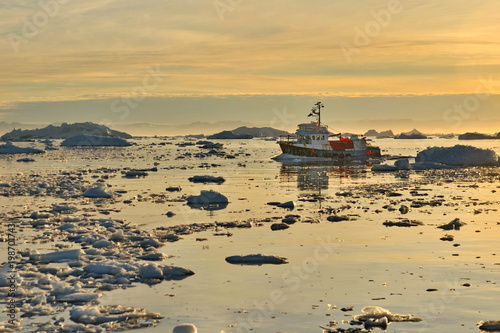 Greenland. Small fishing ships in the water area of the village Ilulissat