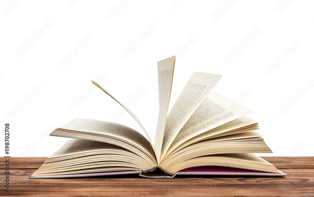 Opened book on the wooden table. Isolated on white. Opened book on the wooden table. Isolated on white.