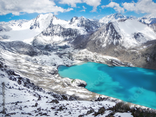 Smaragd water of misty Ala Kul lake in Terskey Alatoo mountains, Karakol national park, Kyrgyzstan photo