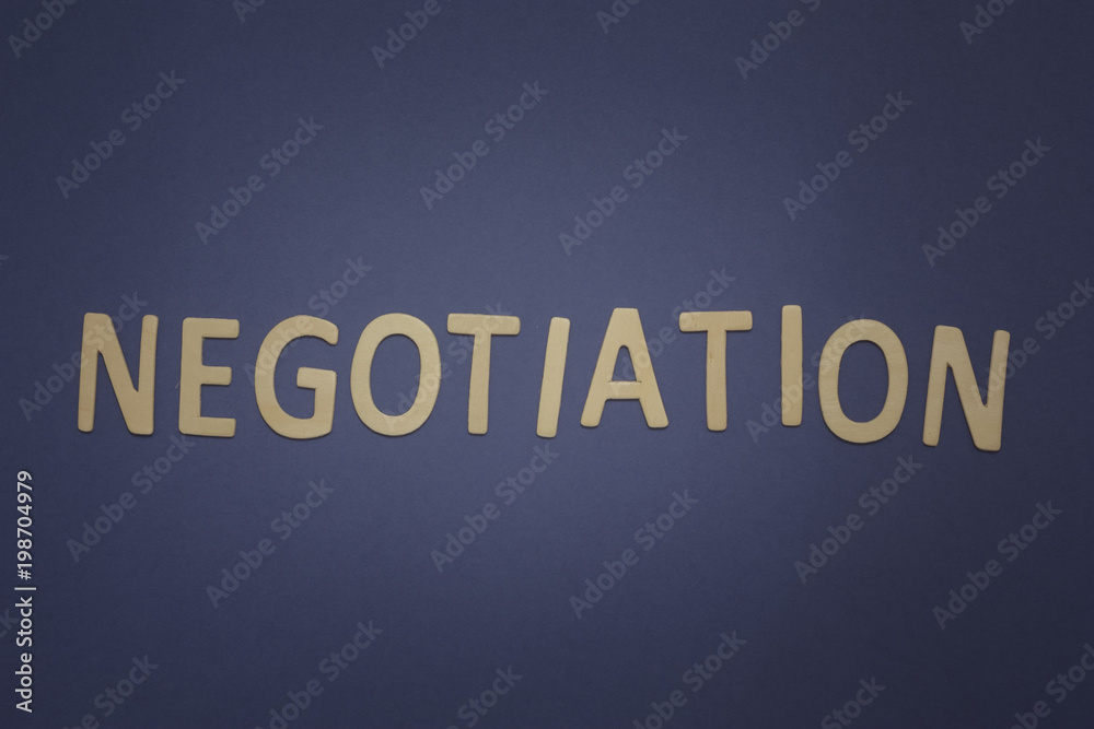 Negotiation written with wooden letters on a blue background Negotiation written with wooden letters on a blue background