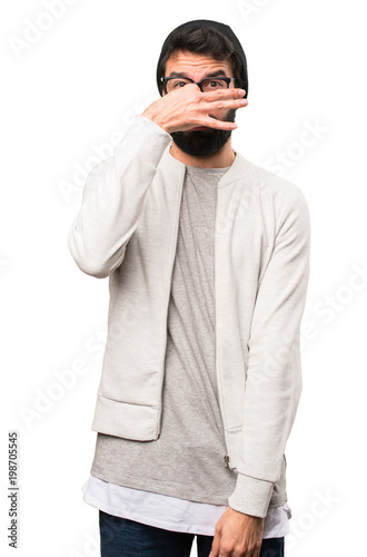 Hipster man making smelling bad gesture on white background