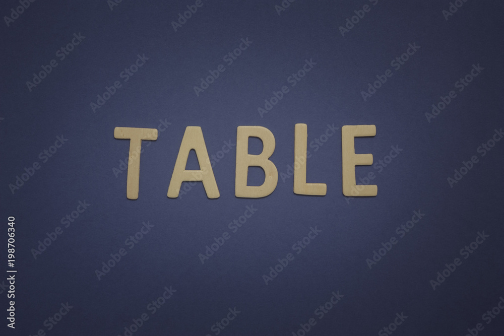 Table written with wooden letters on a blue background to mean a business concept Table written with wooden letters on a blue background to mean a business concept
