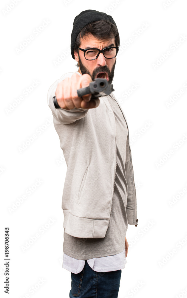 Hipster man shooting with a pistol on white background Hipster man shooting with a pistol on white background