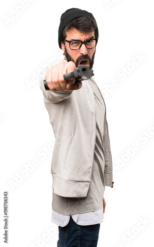 Hipster man shooting with a pistol on white background