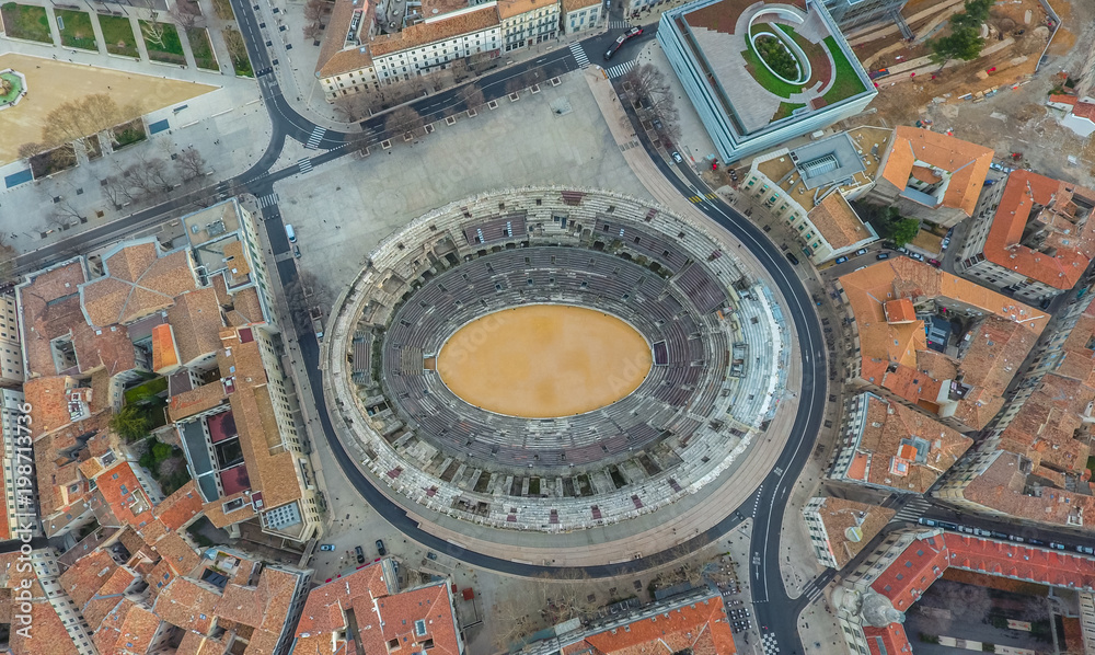 Top view of the ancient arena surrounded by city buildings. Nimes, France. Top view of the ancient arena surrounded by city buildings. Nimes, France.