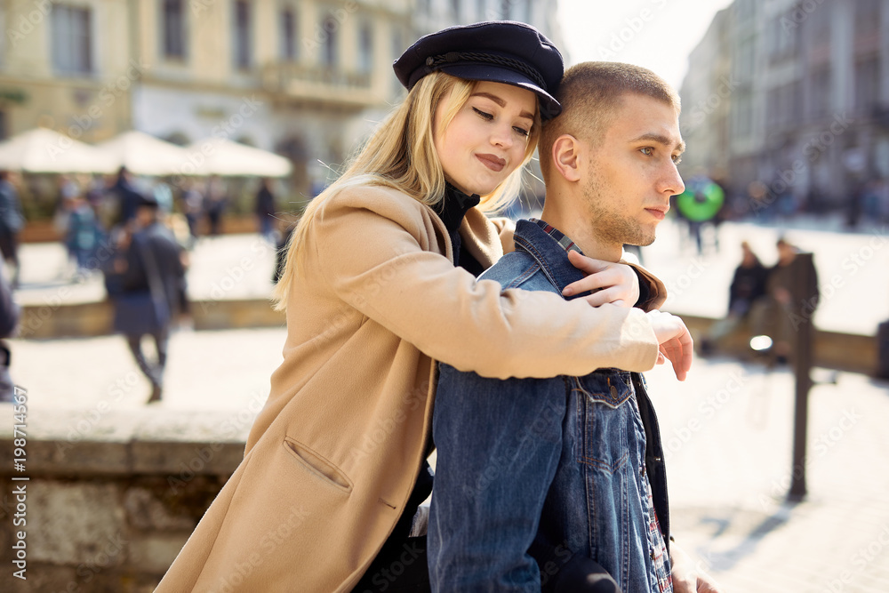 Fototapeta premium Lovely couple stand on city landscape and hug each other with sun on background