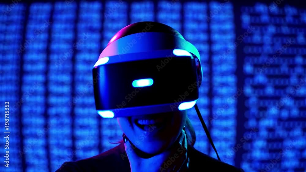 Young woman in VR headset laughs a lot and have fun. Virtual reality interactive helmet on brarcode matrix background Young woman in VR headset laughs a lot and have fun. Virtual reality interactive helmet on brarcode matrix background