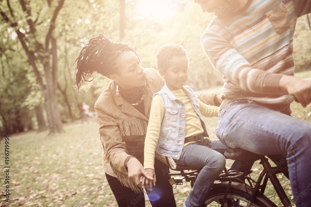 African American Father driving daughter on bike. African American Father driving daughter on bike.