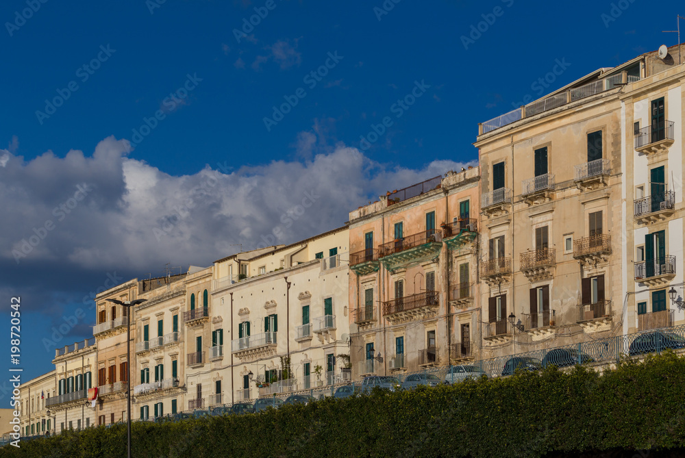 Row of buildings at the tree-lined seafront promenage on the Isle of Ortygia