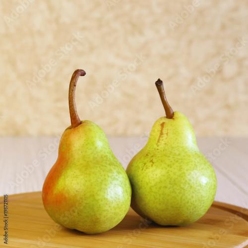 Food. Vegetarian fruit dessert. Healthy eating. Fresh fruits. Two ripe pears on a table in the sunlight.