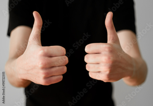 A man in a black t-shirt shows thumb up, success