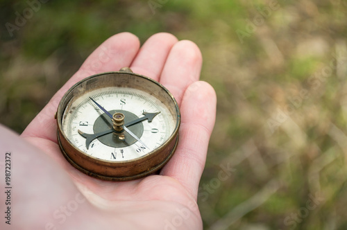 Traveler holding compass in hand. Compass in a hand blurred background