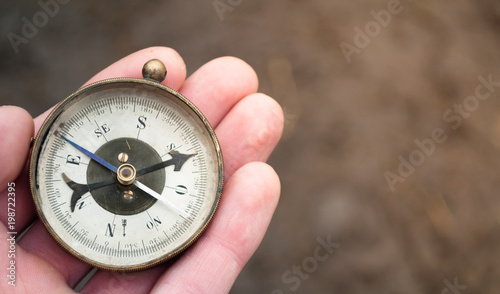 Traveler holding compass in hand. Compass in a hand blurred background