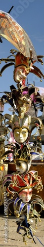 vertical image of masks of various colors of venice carnival