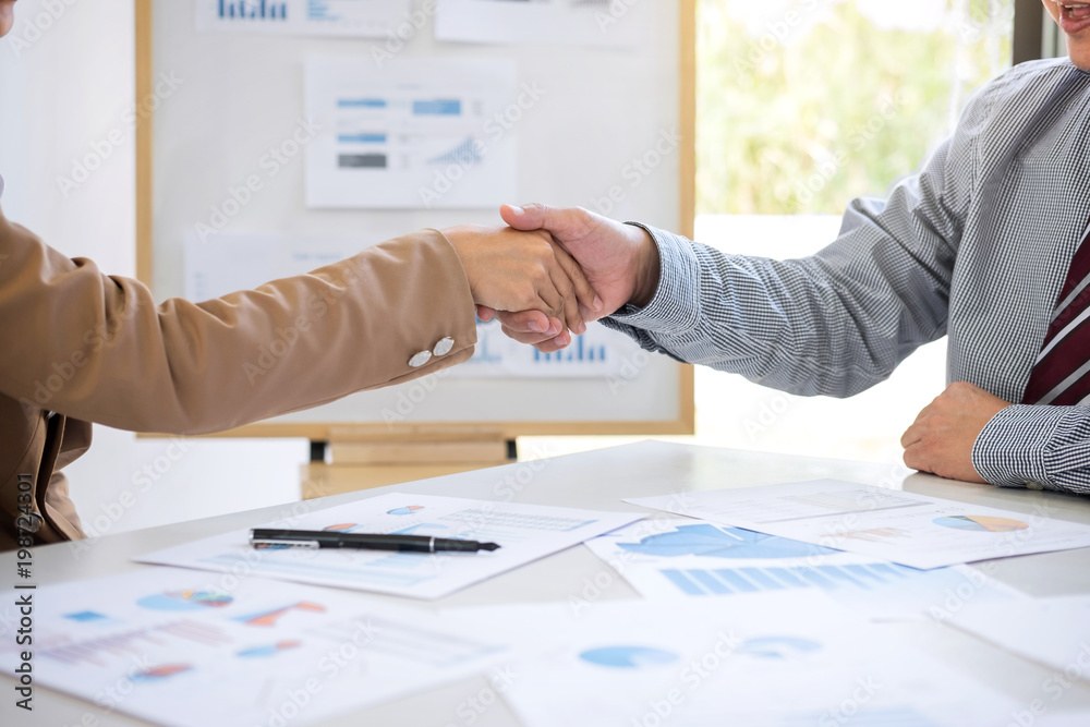 Two business people shaking hands during a meeting to sign agreement and become a business partner in the office, success, dealing, greeting & business partner concept, contract between their firms Two business people shaking hands during a meeting to sign agreement and become a business partner in the office, success, dealing, greeting & business partner concept, contract between their firms