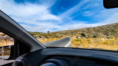 View of the road through the windshield of the car. Mountain landscape. Travel by rented car.