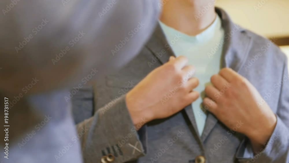 Guy Dressed in New Jacket Poses in front of Mirror