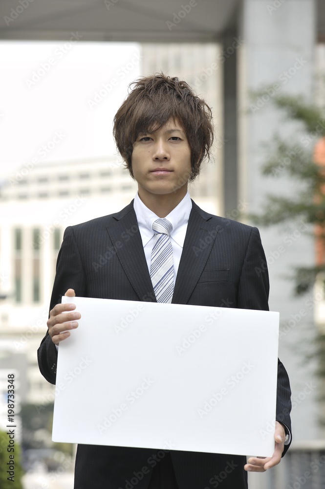 ホワイトボードを持った若いビジネスマン