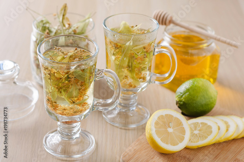 herbal tea with lemon and honey in a glass on a dark light background