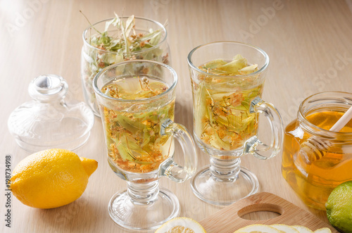 herbal tea with lemon and honey in a glass on a dark light background
