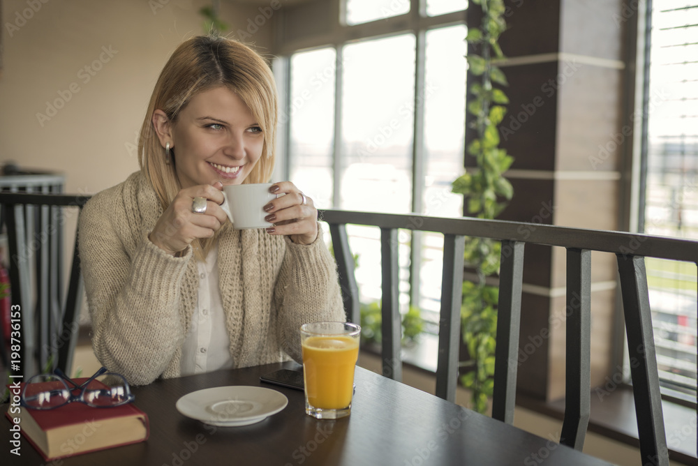 Portrait of young gorgeous female drinking cup of coffee and enjoying her leisure time alone Portrait of young gorgeous female drinking cup of coffee and enjoying her leisure time alone