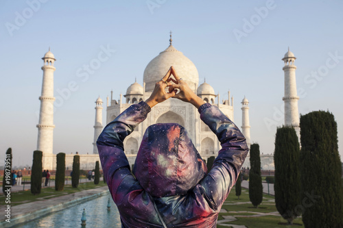 Woman tourist doing yoga mudra infront of Taj Mahal, India