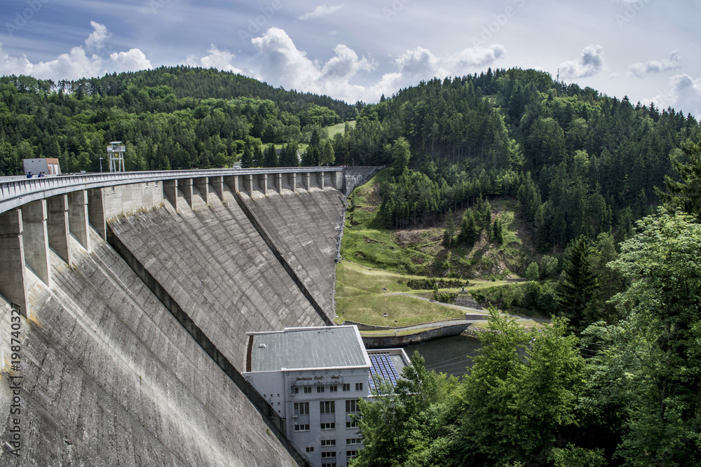concrete big dyke dam in the middle of forests in the summer valley
