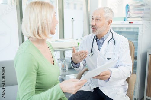 Doctor explaining to his patient details of medical prescription during appointment in clinics